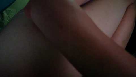A close-up video of a person's bare skin with visible bruising and discoloration, likely indicating an injury. The background is blurred, making the focus on the skin. The lighting is dim, casting shadows and highlighting the texture of the skin.