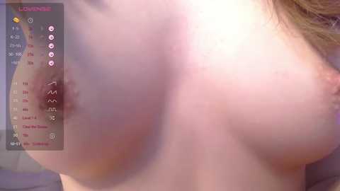 Media: A close-up video of a nude woman's bare breast, showing light pink skin and a small, erect nipple. The image also includes a digital display with measurement data.