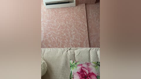 Media: A video showing a beige sofa with a floral cushion featuring a pink rose, juxtaposed against pink and white patterned carpeting. An air conditioner is mounted on the wall behind the sofa.