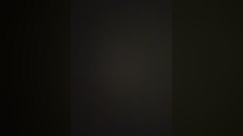 A video featuring a dark, featureless background with a central, subtle light gradient, creating a subtle contrast. The image lacks identifiable objects or details, emphasizing a minimalist, abstract aesthetic.