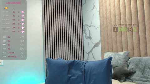 Video of a modern living room with a blue couch, striped and wooden-paneled walls, and a digital clock displaying 6:04 AM.