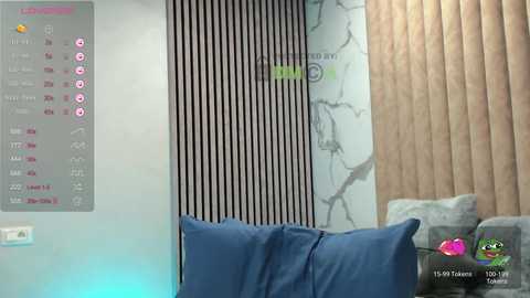 A video of a modern living room with a gray sofa, wooden wall, and vertical black and white stripes. The digital clock displays 4:36 PM, and a virtual assistant screen shows weather and news.