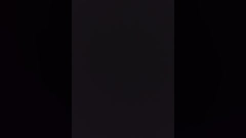 A video featuring a central, vertical black stripe surrounded by pitch-black background, creating a stark contrast. The image lacks discernible details, textures, or objects, focusing solely on the darkness and its uniformity.