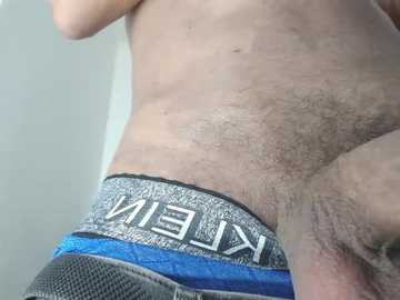 Video of a light-skinned, hairy male abdomen with visible navel, wearing Calvin Klein blue and grey athletic shorts.