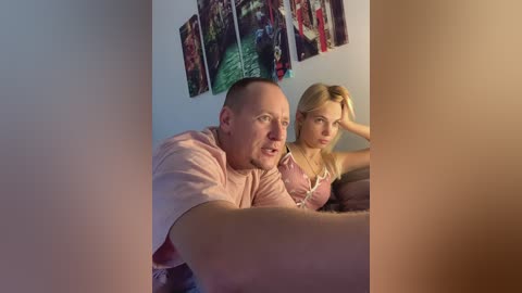 Media: A video of a man and a blonde woman sitting on a couch, both looking serious. The woman rests her head on her hand.