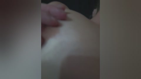 A blurry video showing a close-up of a hand holding a piece of paper, with a background that is out of focus.