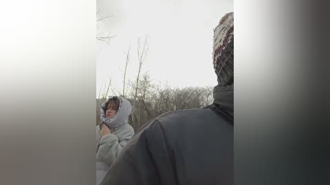 Media: Video of a young girl in a gray hoodie, standing in a misty forest, with a large, hairy creature partially visible in the foreground.