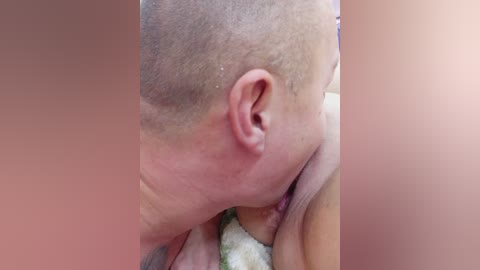 Media: Close-up video of a person with a bald head, light skin, and a tattoo on their arm, performing oral sex on a person with a light brown, hairy arm.