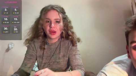 Media: A video of a young girl with curly hair, wearing a textured gray sweater, talking on a bed. A weather app is visible on the left.