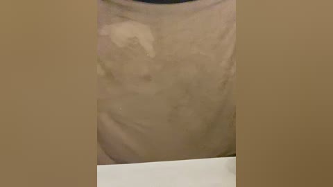 Video of a close-up of a person's upper torso, focusing on the chest and abdomen, showing a light brown, possibly tan, skin tone with a circular, white, slightly blurred mark in the center.