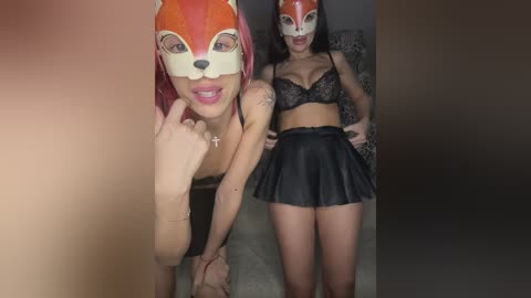 Video: Two women, one in a fox mask, the other in a black lace bra and short skirt, standing in a dimly lit room, holding hands.