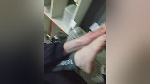 Media: A blurred video shows a person's bare feet in a dark outfit, being held down on a table, with medical equipment in the background.