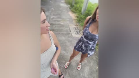 Media: Video of two women walking on a street. One wears a grey tank top, and the other a tie-dye dress. They are talking and smiling.
