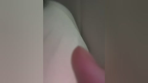 Video of a close-up, blurred view of a person's erect penis with a red tip, partially obscured by a hand, suggesting intimacy. The background is indistinct, with soft, muted tones.
