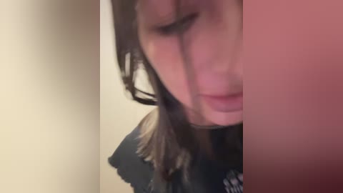 Media: A blurred, close-up video of a person with long brown hair, possibly a young woman, partially obscured by a pinkish blur in the foreground.