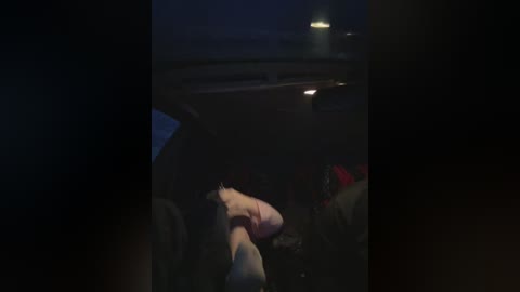 Media: A dimly lit video captures the inside of a vehicle at night, featuring a person, possibly a driver, with their head down, possibly asleep, and a red object in the background.