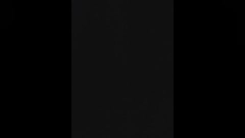 A video of a black vertical rectangle against a pitch-black background, creating a stark contrast and emphasizing the solid, monochromatic nature of the subject.