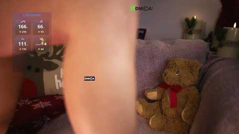 Media: A video of a virtual reality headset, displaying a VR scene featuring a plush teddy bear on a couch, surrounded by festive decorations, including a Christmas tree and presents.