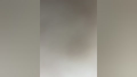 A video of a plain, light gray wall with a slight shadow in the center, creating a subtle gradient effect. The image is devoid of any objects or textures, focusing solely on the wall's smooth surface.