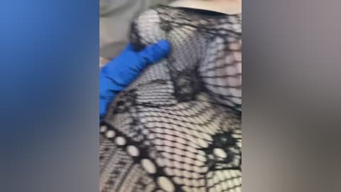 Video showing a close-up of a person's chest covered in a black lace bra with intricate floral patterns, partially obscured by a blue-gloved hand, possibly indicating medical intervention.