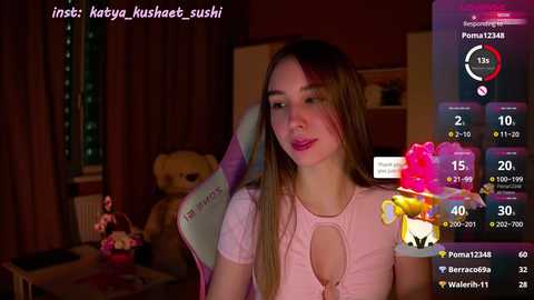 Media: Video of a young Asian woman with long, straight hair, wearing a pink top, in a dimly-lit bedroom with a plush teddy bear and window. Social media app interface overlays the image.