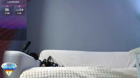 A video of a modern living room with a white couch, a diamond logo, and a TV screen displaying a virtual reality scene.