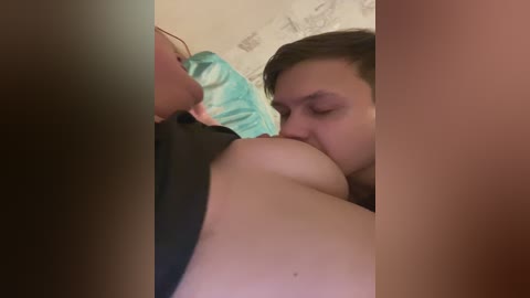 A video shows a woman with medium skin tone and short brown hair, performing oral sex on a man with a medium skin tone. The background is blurred, featuring a floral wallpaper.