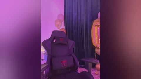 Video of a black gaming chair with a red logo and an orange cushion, set against a purple-lit room with balloons and a golden throne.