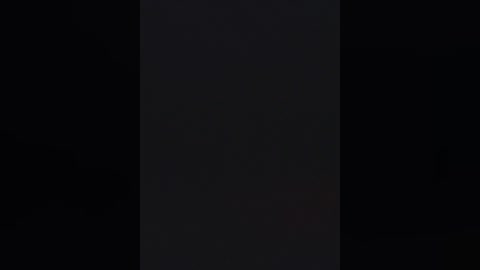 A dark, monochrome image featuring a vertical, slightly off-center black bar against a pitch-black background, creating a stark contrast that emphasizes the bar's presence. The image is minimalistic, with no additional elements or textures.