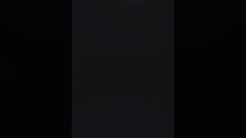 A dimly lit video featuring a vertical black stripe in the center of a dark background, with minimal contrast and no discernible objects or details.