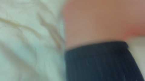 Media: A blurred video featuring a close-up of a person's torso in a white shirt and dark pants, with a pinkish hue in the background.
