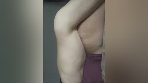 Video of a light-skinned individual in profile, wearing a maroon thong, captured from the side, highlighting the curvature of the body and the fabric's texture.