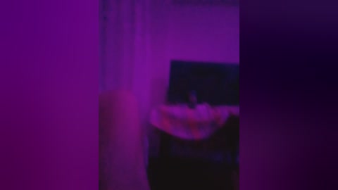 A blurry video with a purple hue, showing a person in a black jacket, partially obscured by a curtain. The image is slightly out of focus, creating a dreamy, ethereal atmosphere.