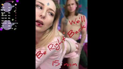 Video of two young women with pale skin, one topless, the other in a pink top, both with blonde hair. Text reads \"Be Right Back 15 min.\