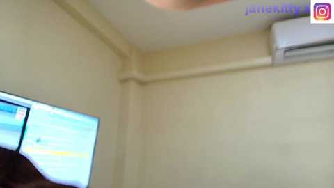 Video of a beige room with a flat-screen TV on the left, displaying a blue screen, and an air conditioner mounted on the right wall.