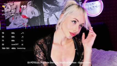 Video of a blonde woman in a black lace top, looking seductively at the camera, with a close-up of a man's face in the background. Text overlays indicate a live stream.