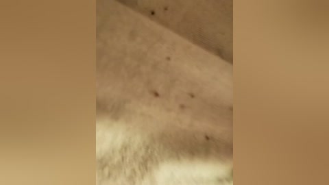 A video of a close-up view of a person's skin, showing uneven texture and dark spots, likely caused by acne or skin conditions. The background is blurred, emphasizing the skin's imperfections.