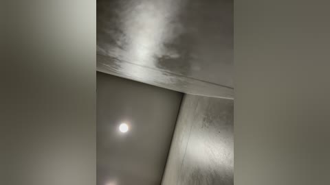 Video of an interior space with a modern, minimalist design. The image features smooth, curved walls and a large, circular light fixture emitting a soft glow, creating a serene atmosphere.