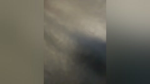 A blurred video featuring a dark, hazy sky with dense, swirling clouds, creating a mysterious and ominous atmosphere. The image lacks distinct details and clear subjects, emphasizing a sense of uncertainty and the unknown.