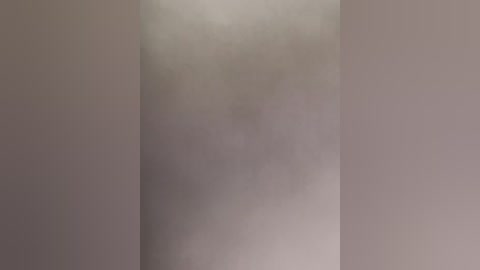 Video of a plain, beige wall with a subtle, faint shadow on the left side, creating a subtle gradient effect. The image has a minimalist, muted aesthetic with no discernible objects or textures.