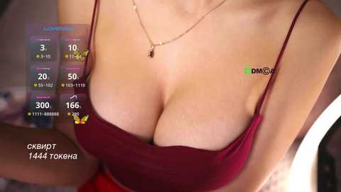 Video of a woman's cleavage in a red spaghetti-strap top, showcasing fair skin, necklace, and a blurred background.