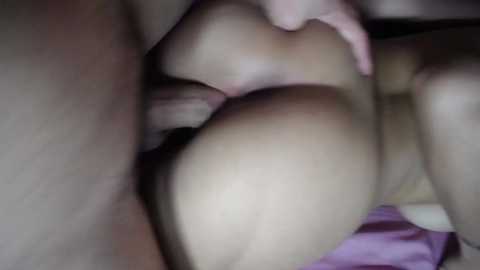 Video of a close-up, intimate scene featuring two nude individuals engaged in sexual activity. The image captures the act from a side angle, focusing on the lower bodies, with one person's hand gently holding the other's buttock.
