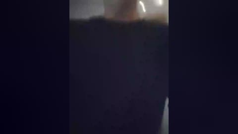 A video capturing a dark, stormy night sky with a lightning bolt striking the ground, partially visible in the center. The image is dimly lit, emphasizing the dramatic and ominous atmosphere.