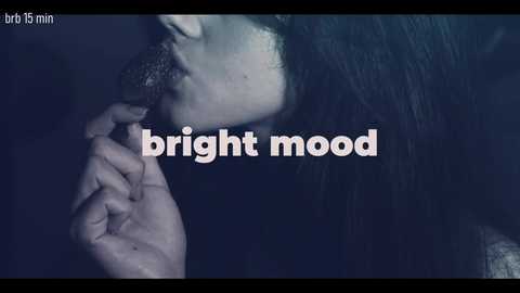 Video of a person with long black hair, pale skin, and a trimmed mustache, holding a cigarette, against a dark, moody background. Text overlay reads \"bright mood\" in white, lowercase letters.