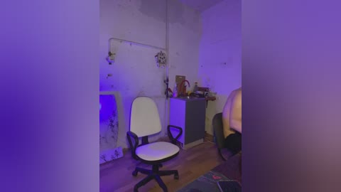 A dimly lit, sparsely furnished room with purple lighting, featuring a white office chair, a small desk, and a wall with peeling paint and a metal shelf.