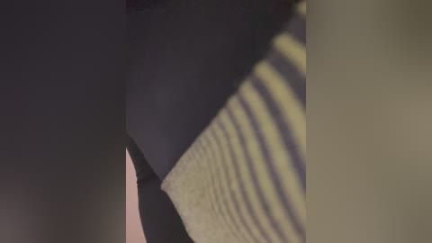 A close-up video of a person's bare, smooth, light-skinned thigh with visible veins, partially obscured by a textured, light-colored cloth. The background is dimly lit, creating a moody, intimate atmosphere.