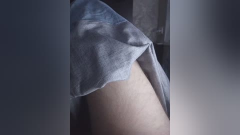 Video of a close-up view of a person's bare buttocks with a light blue towel draped over them. The background is blurred, focusing on the towel's texture and the skin's natural contours.