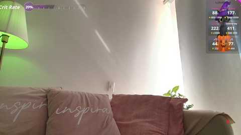 Video of a cozy living room featuring a beige sofa with \"Envision\" text pillows, a green lamp, and a colorful TV displaying a soccer game.