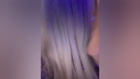Video of long, flowing hair transitioning from light purple to white, with a soft, ethereal glow. The background is a blurred mix of warm and cool tones, creating a dreamy ambiance.