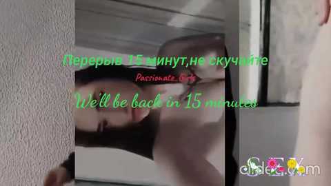 A blurry video of a woman's face with dark hair, partially reflected in a mirror. Text overlaid in green and pink reads, \"We'll be back in 15 minutes.\